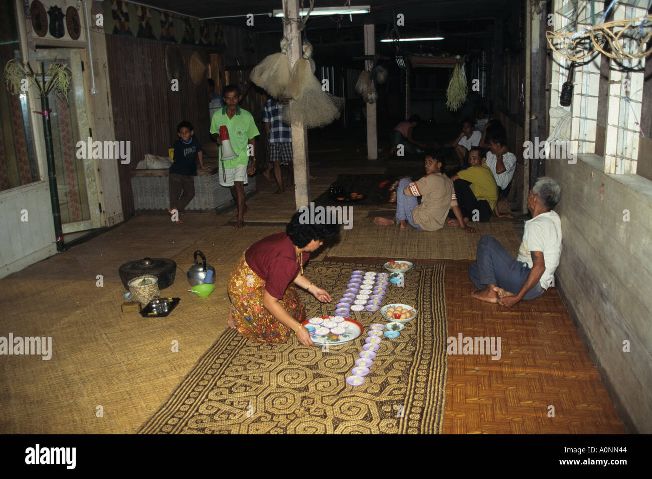 Dayak women and men preparing offerings in the longhouse on Rajang river Sarawak Malaysia Stock Photo