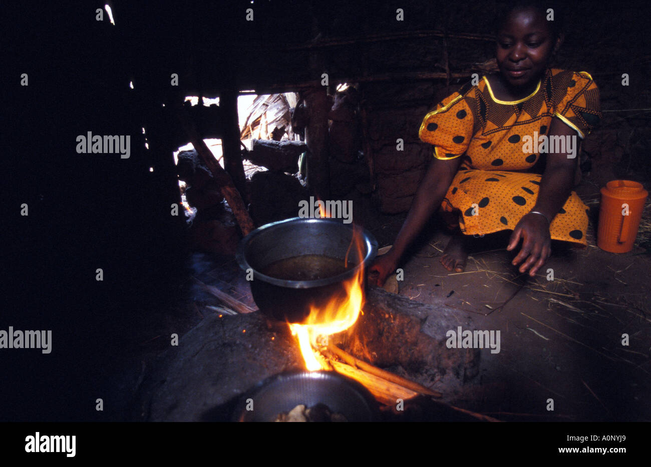 Kagera a woman preparing breakfast on an open fire in her primitive kitchen Stock Photo