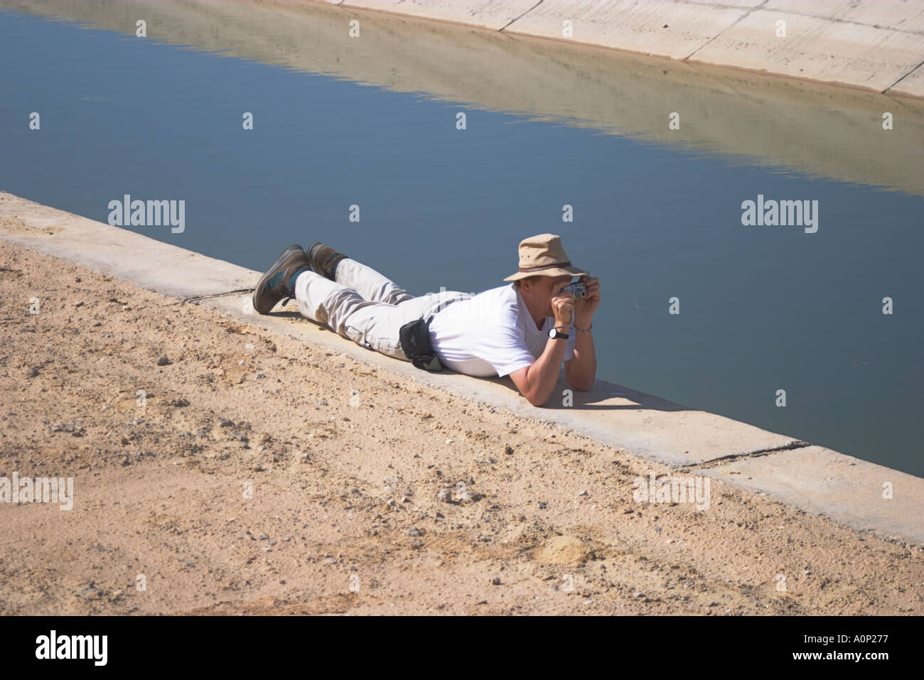 A Tourist photographs a fresh water channel running alongside Egypt s Bitter Lakes Stock Photo