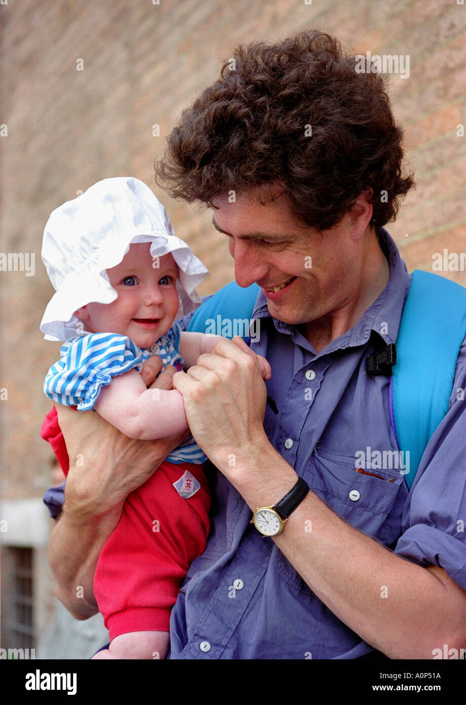 father carrying baby daughter, wearing cute sunhat Stock Photo