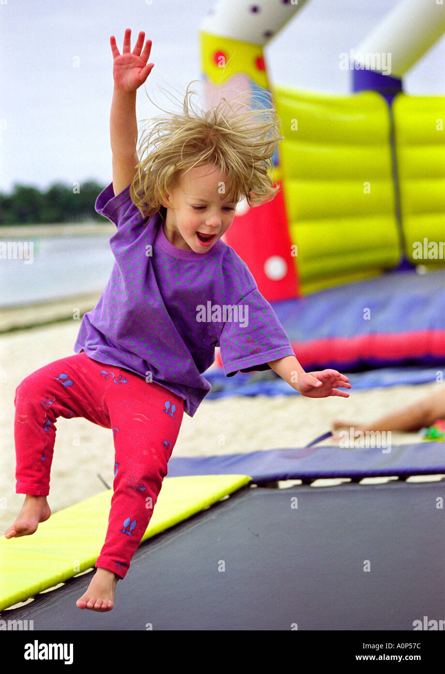 colourful and energetic image of young child up in the air, jumping on a trampoline Stock Photo