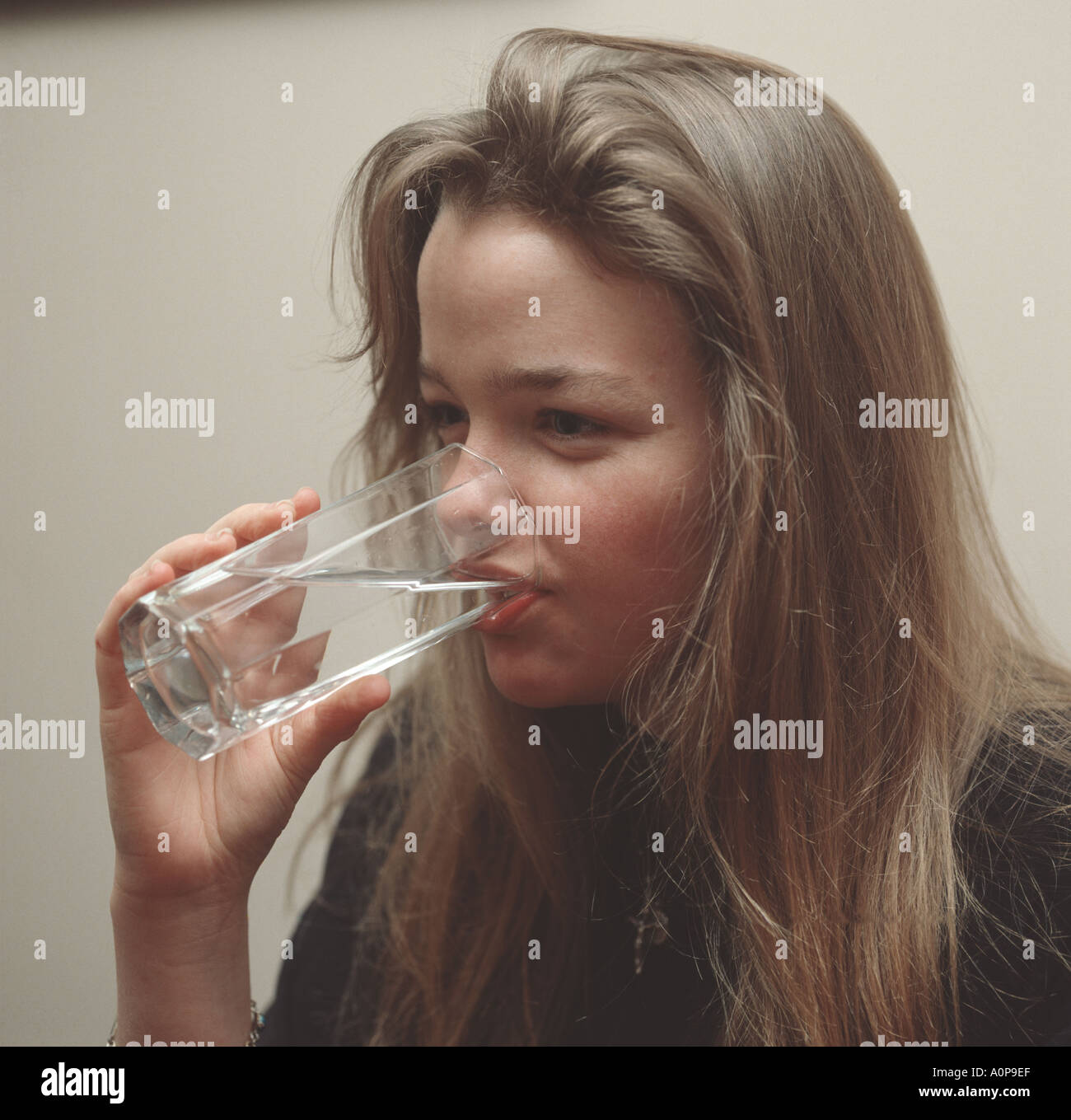 European girl drinking water from a clear glass Stock Photo