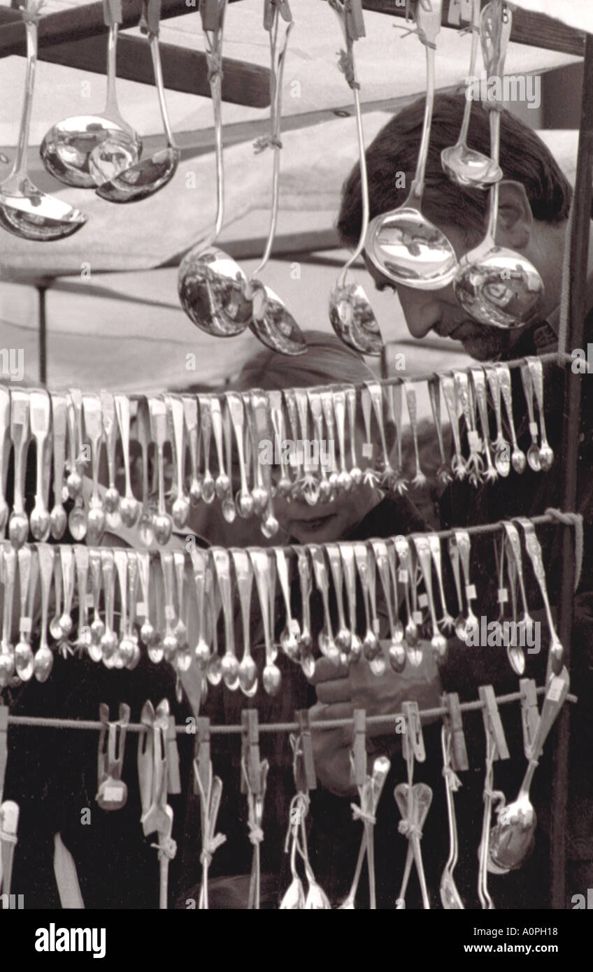 Silver Spoons, Tongs and Ladles Hang From  An Antique Stall Stock Photo