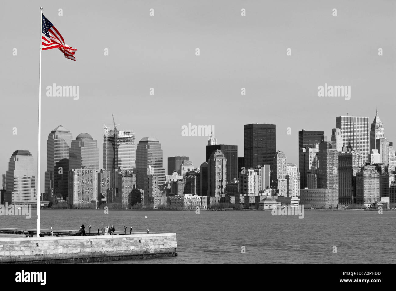 Black and white image of Manhattan island New York City from Liberty island with selectively colored USA American national flag Stock Photo