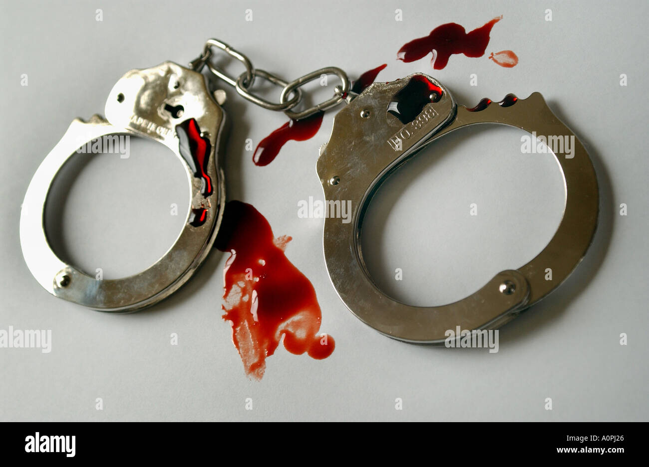 a pair of handcuffs with blood stains on them Stock Photo Alamy