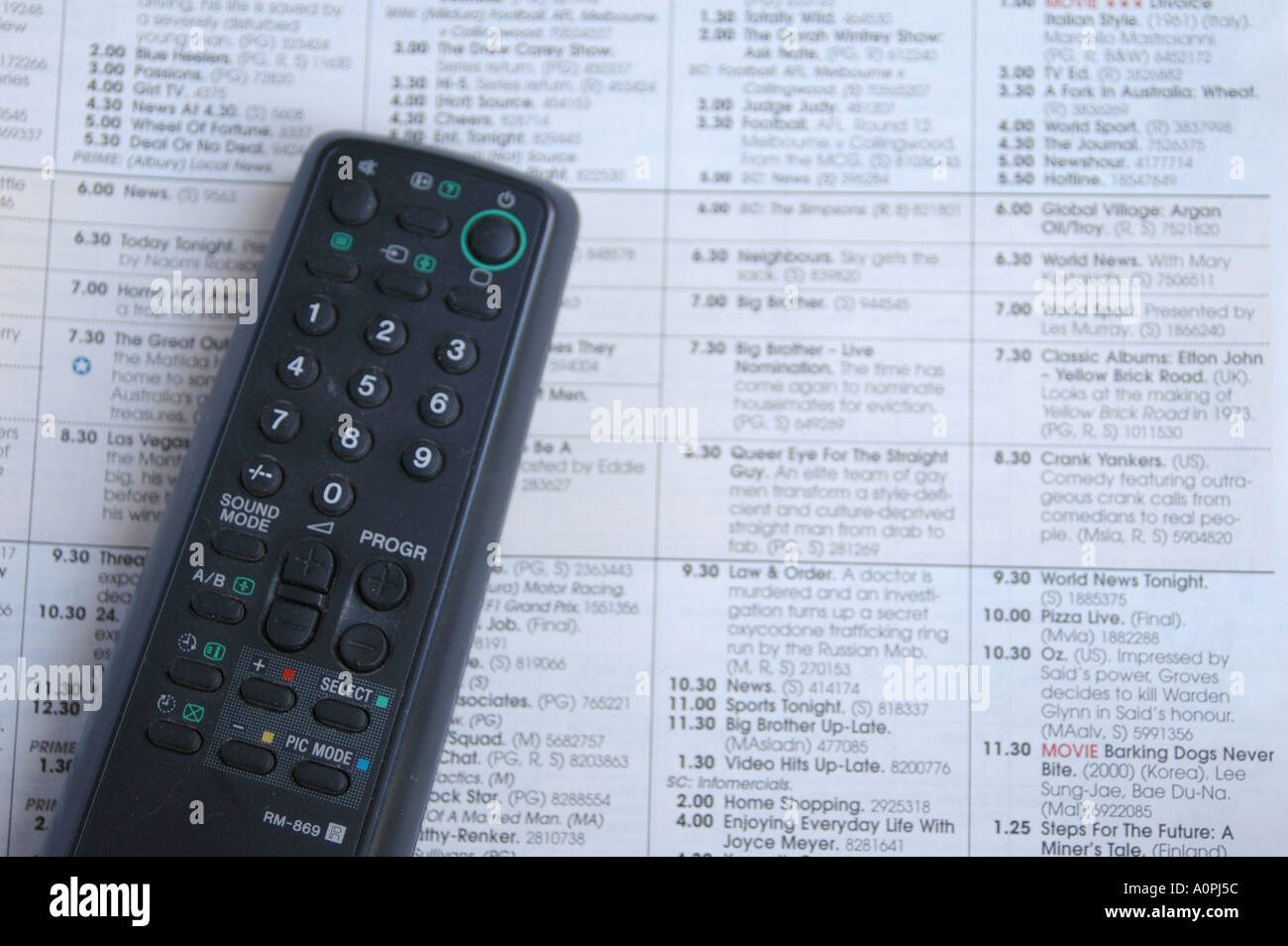 Television remote control and TV program guide Stock Photo