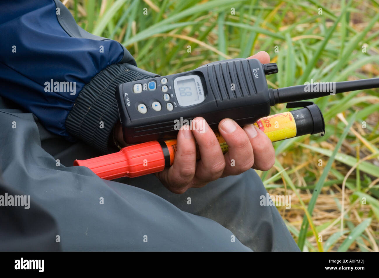 Bear guide holding radio and flare as protection against attack by Grizzly Bear Ursos arctos in coastal creek Katmai Alaska USA Stock Photo