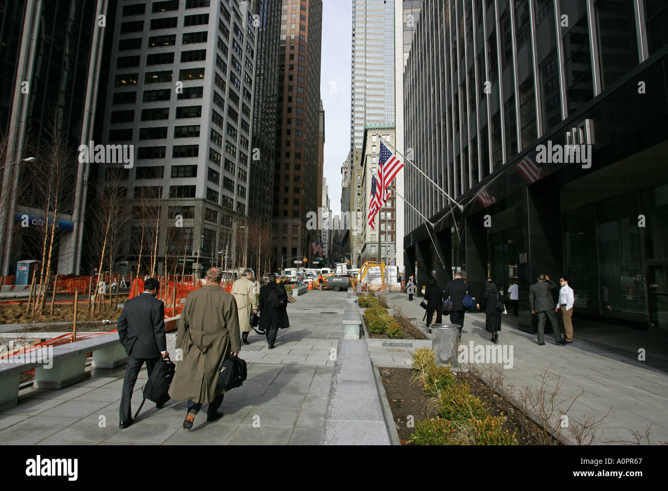 American businessmen carrying brief cases walk towards Wall Street