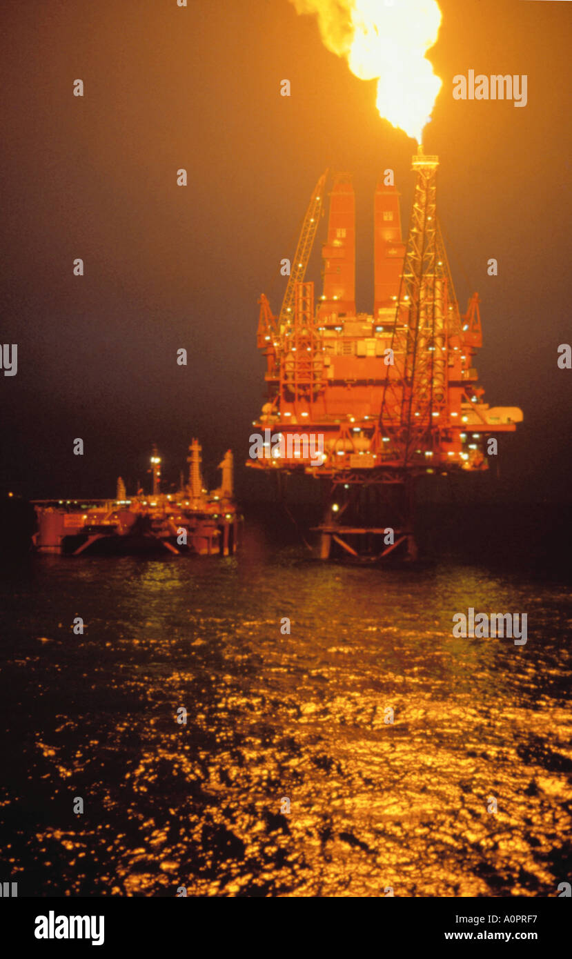 Flaring off gases on the North West Hutton North Sea oil platform at night. Stock Photo