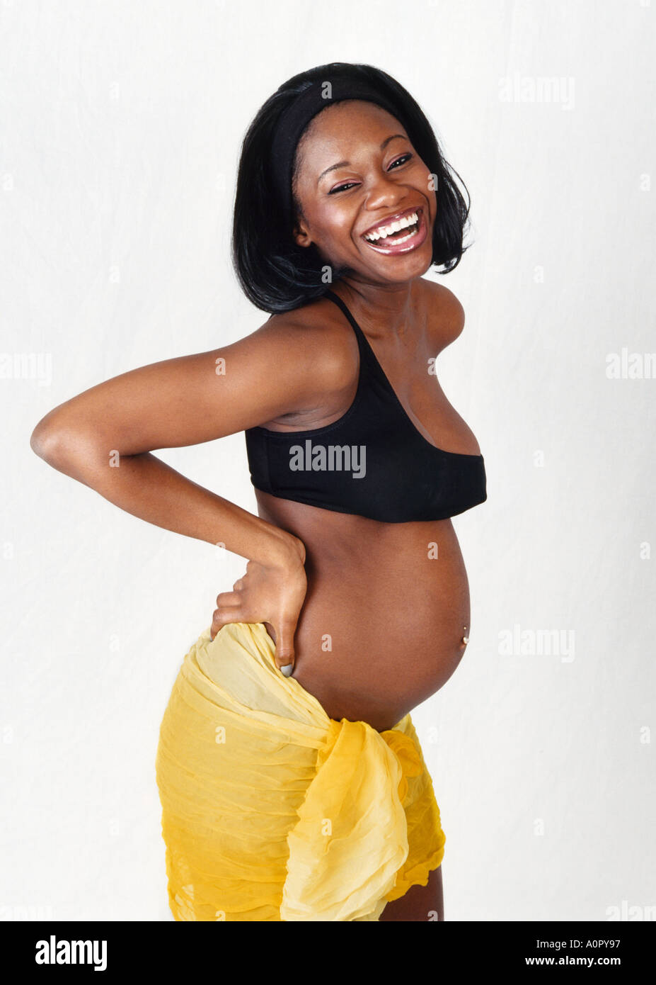 Pregnant Black Girl in Black Bra and Yellow Skirt Stock Photo