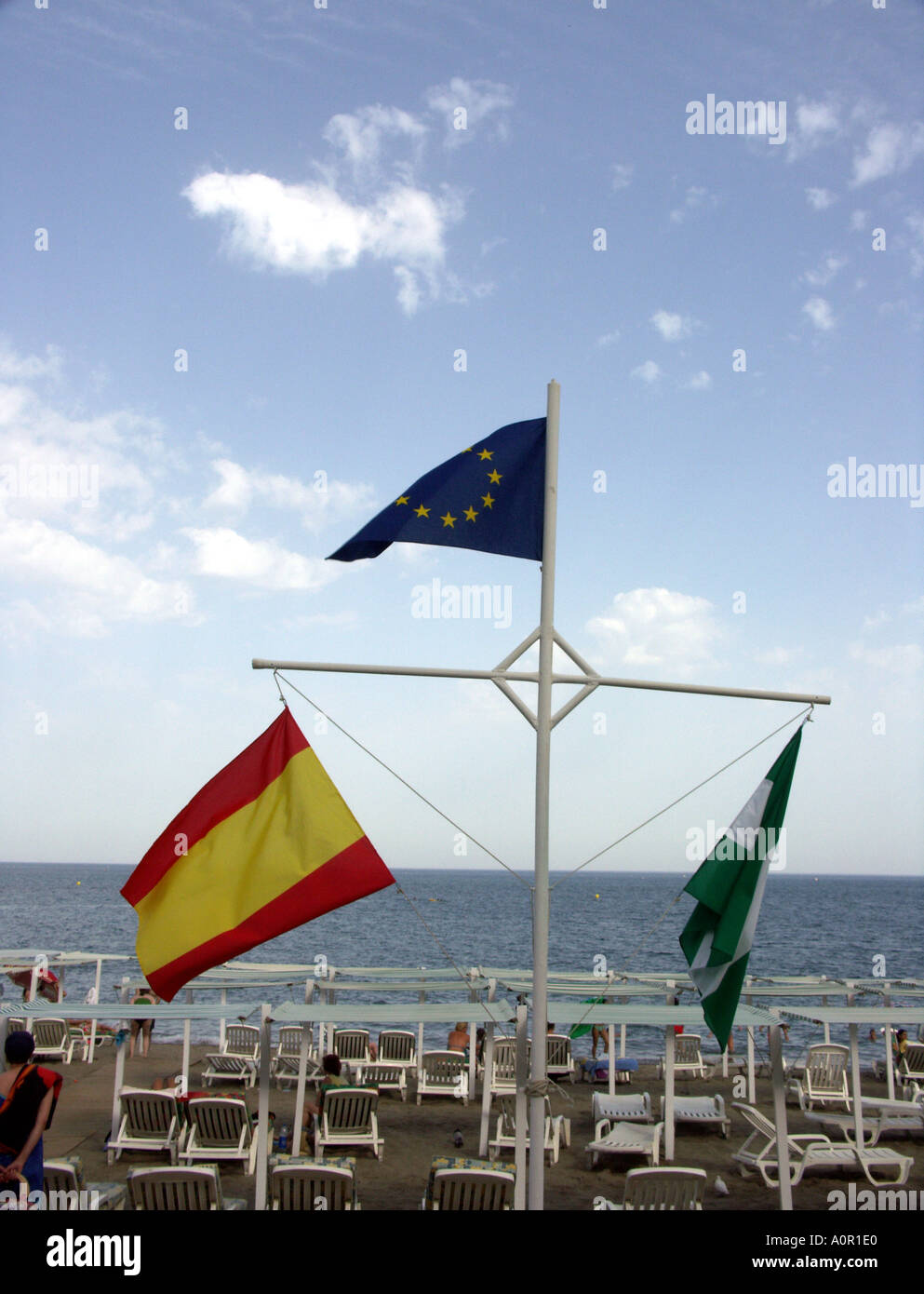 Spanish, Andalucian, and EU  flags flying on the beach, Fuengirola, Costa del Sol, Spain, Europe, Stock Photo