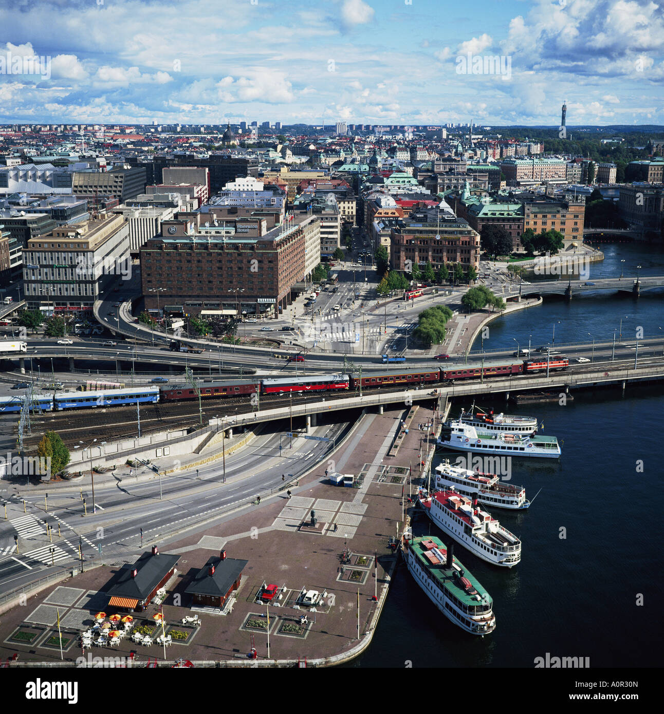 Norrmalm waterfront with cruise boats railway and the Sheraton Hotel Stockholm Sweden Scandinavia Europe Stock Photo