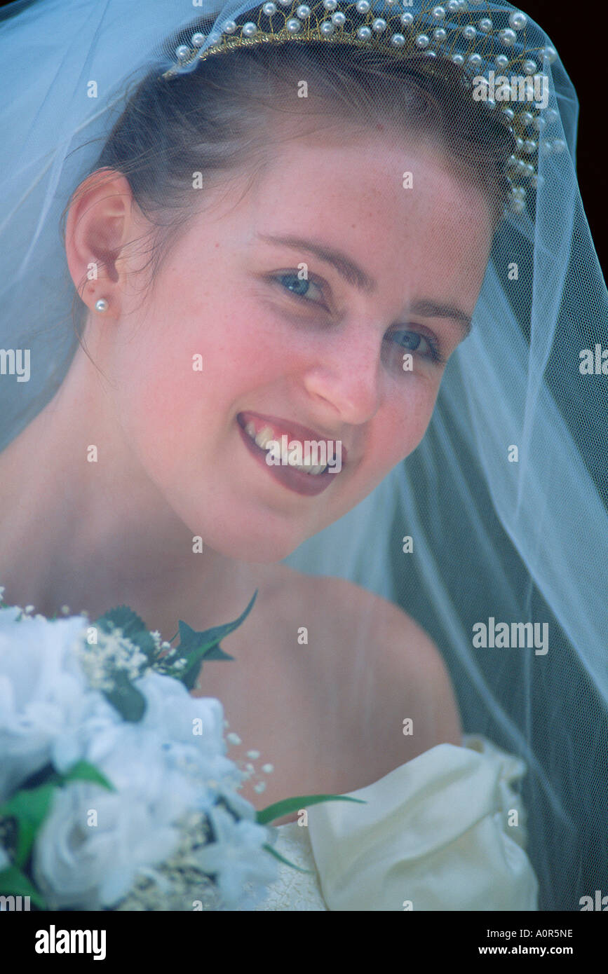 Outdoor portrait of happy young woman bride wearing bridal veil. Stock Photo