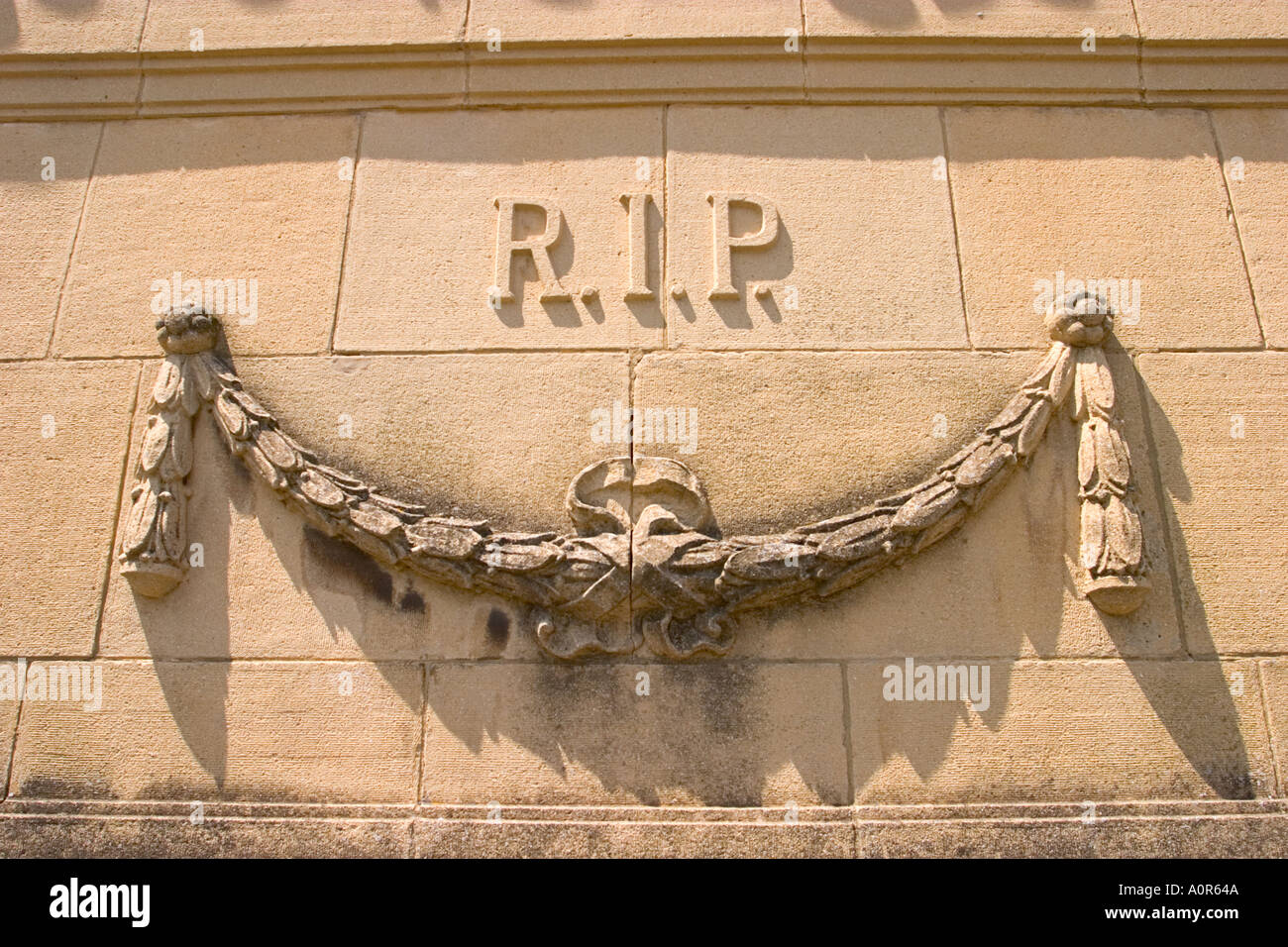 Stone wall reading R.I.P. on a tomb, with a stone garland Stock Photo ...
