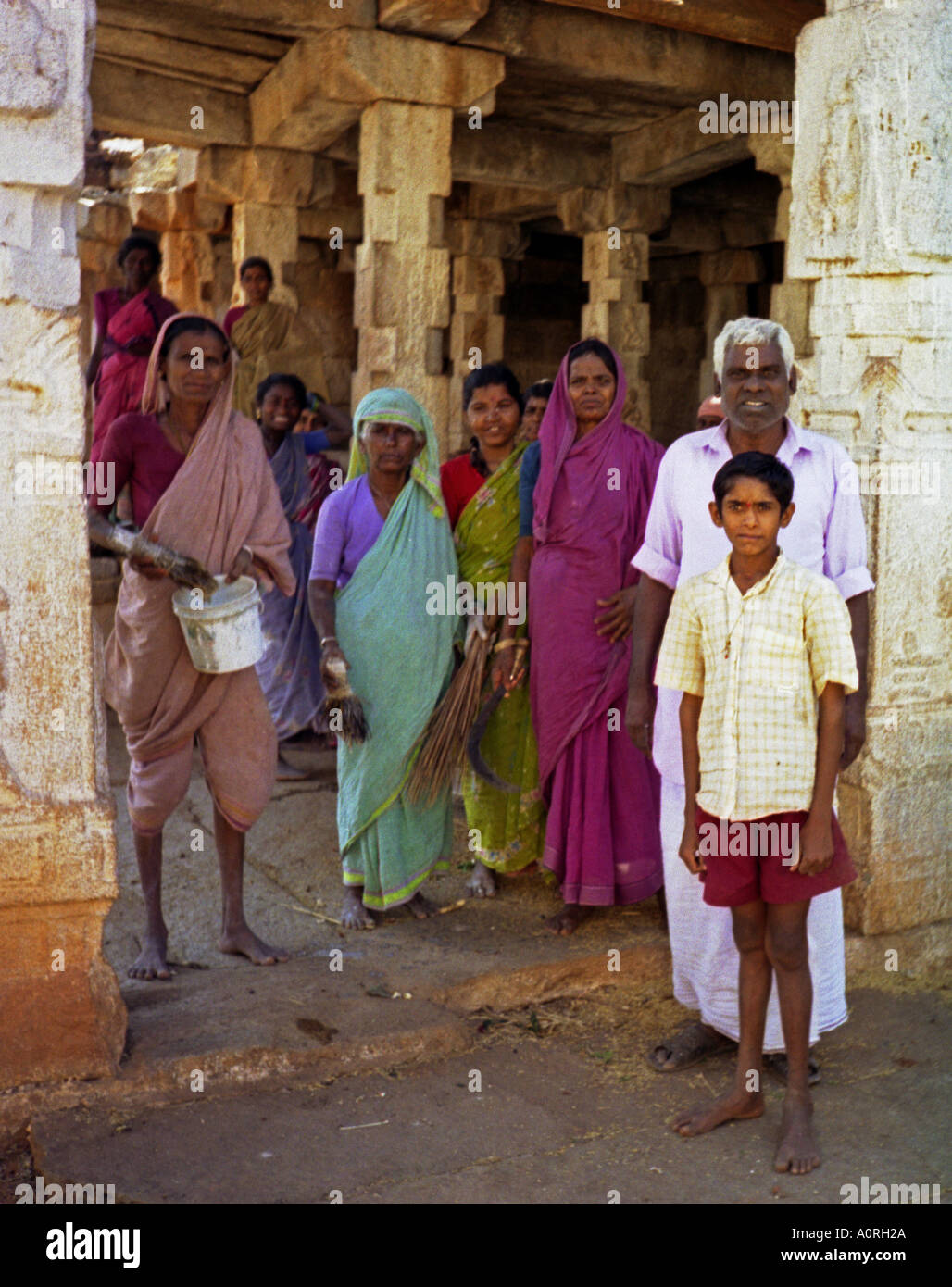 Group of women man & boy in colourful traditional clothing looking after ancient temples - Hampi Karnataka India South Asia Stock Photo