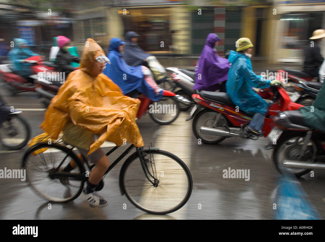 People riding bikes and mopeds in the rain wearing nylon protection Old