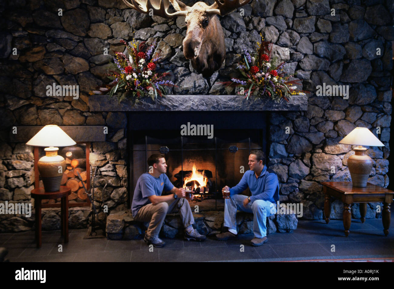 Men beside the fire The Alyeska Resort Girdwood Alaska United States of America North America Stock Photo