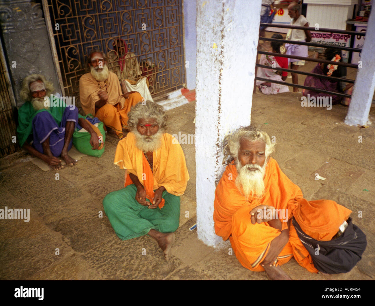 Senile wise white bearded Hindu men man in colourful traditional clothing beg money Palani Tamil Nadu India South Asia Stock Photo