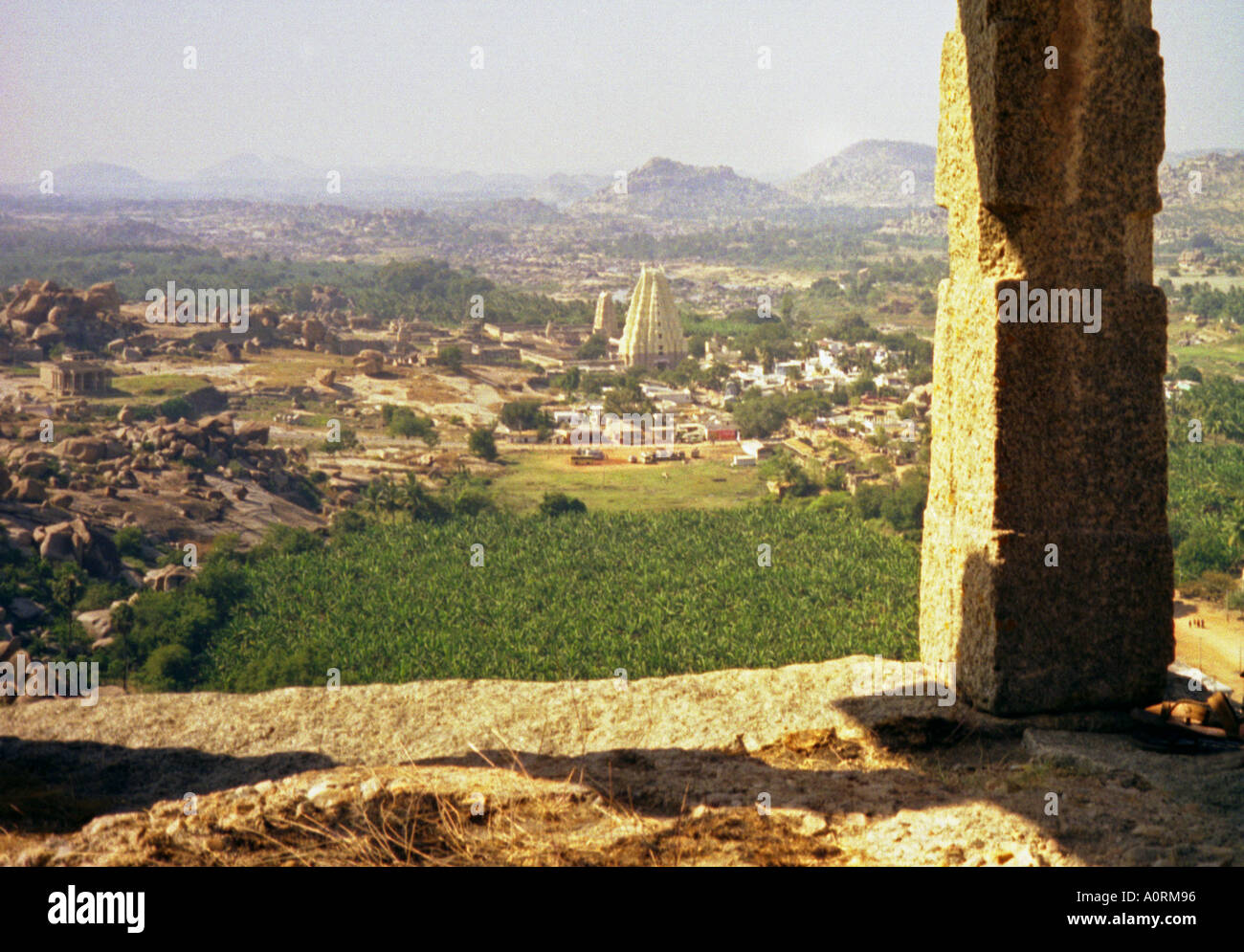 Panoramic view old ancient city ruins Hindu temple seen through a stone door green hill Hampi Karnataka India South Asia Stock Photo