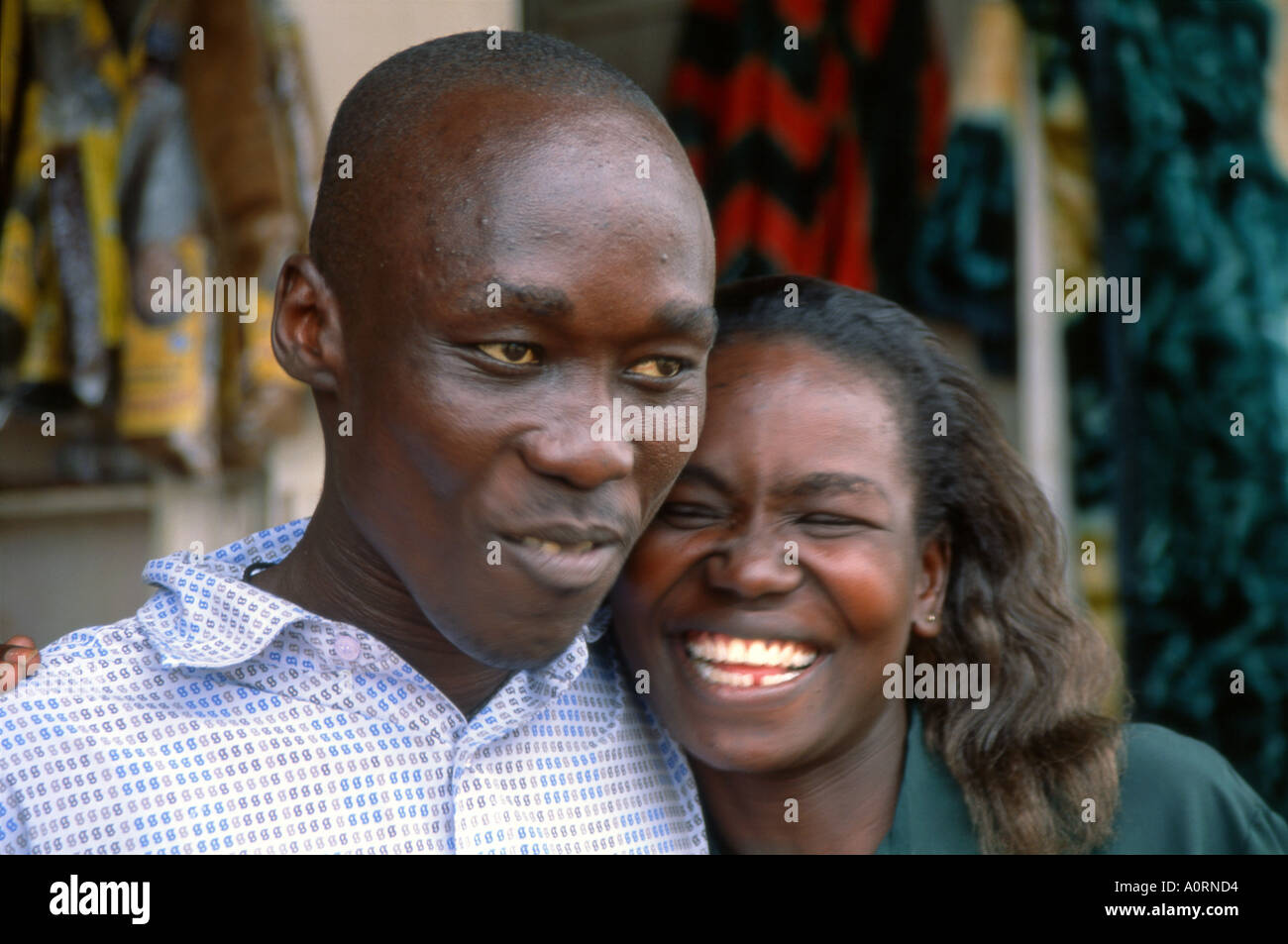 Portrait of smiling young black African man & woman posing together in outdoor location - Jinja City Uganda East Africa Stock Photo