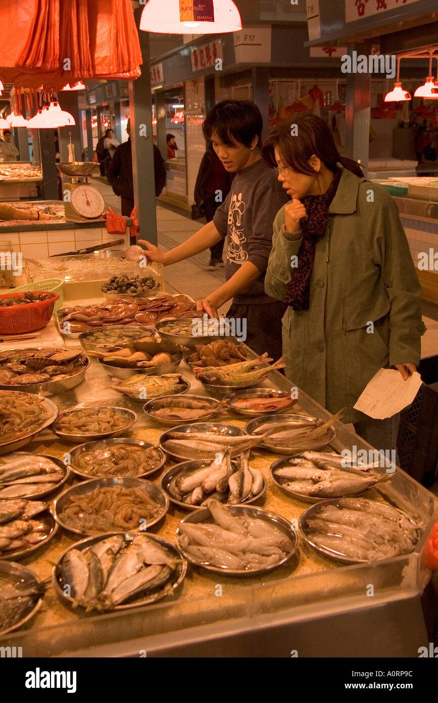 dh Tai Po indoor Market TAIPO WET MARKETS HONG KONG NT Woman Fish stall shop customer fishmonger chinese choosing food shopping China Stock Photo