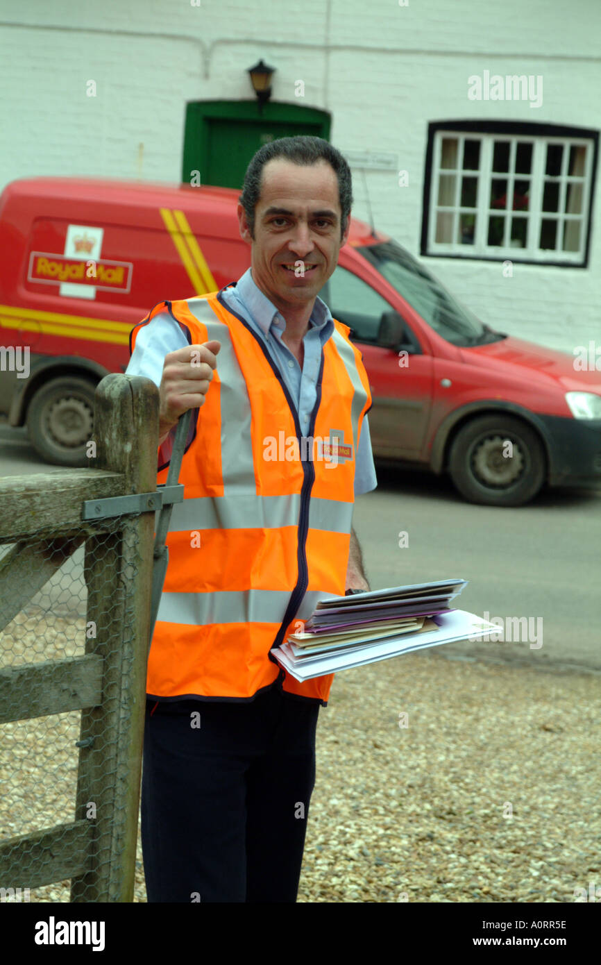 postman delivers letters in rural location England UK Royal Mail Stock Photo