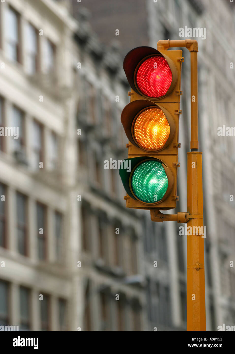 Vertical traffic light with red yellow and green signals illuminated in an urban city background Stock Photo - Alamy