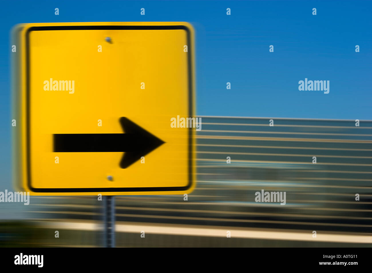 Yellow road sign with black directional arrow Stock Photo
