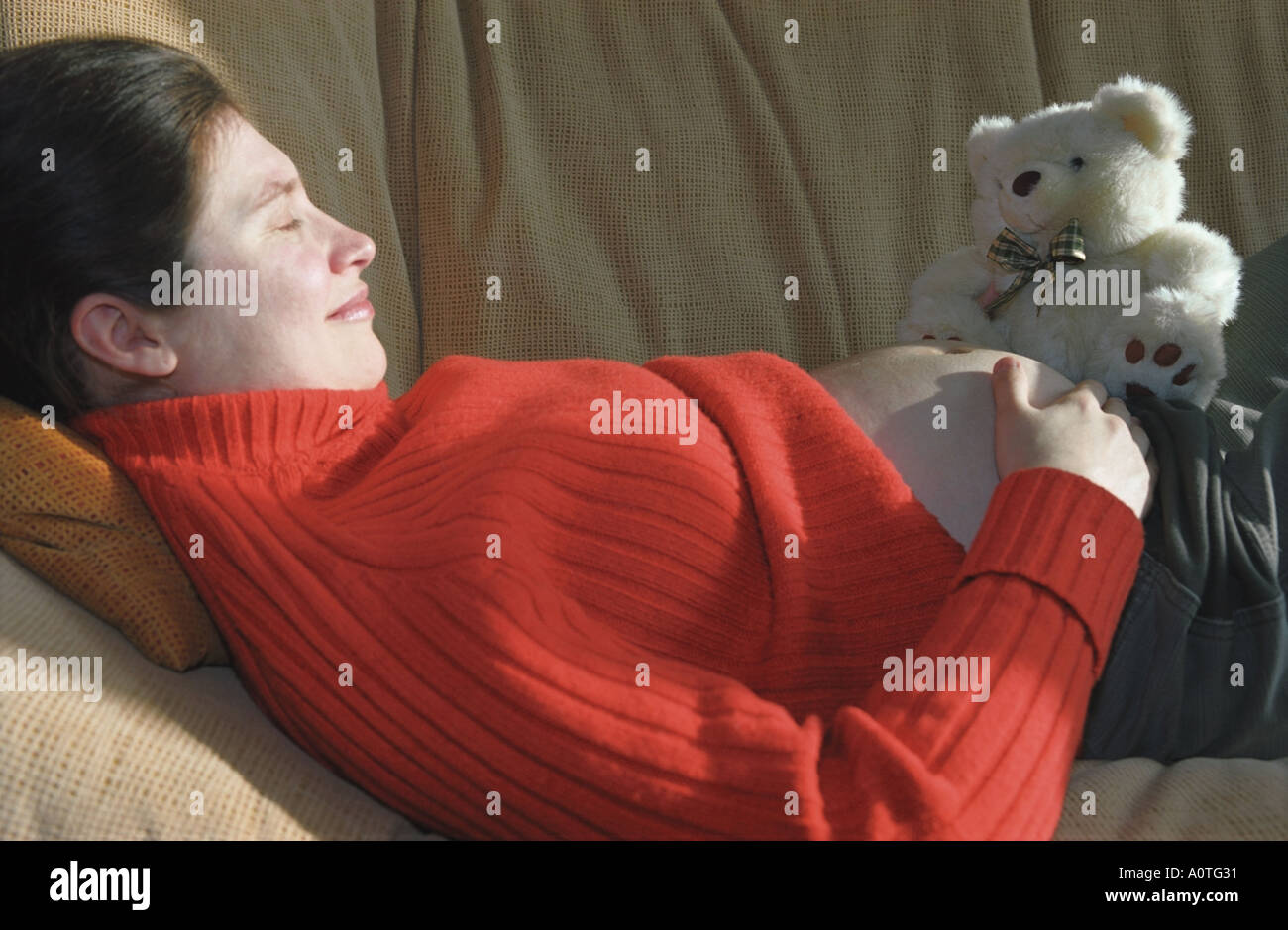 Lying pregnant woman with teddy bear  Stock Photo