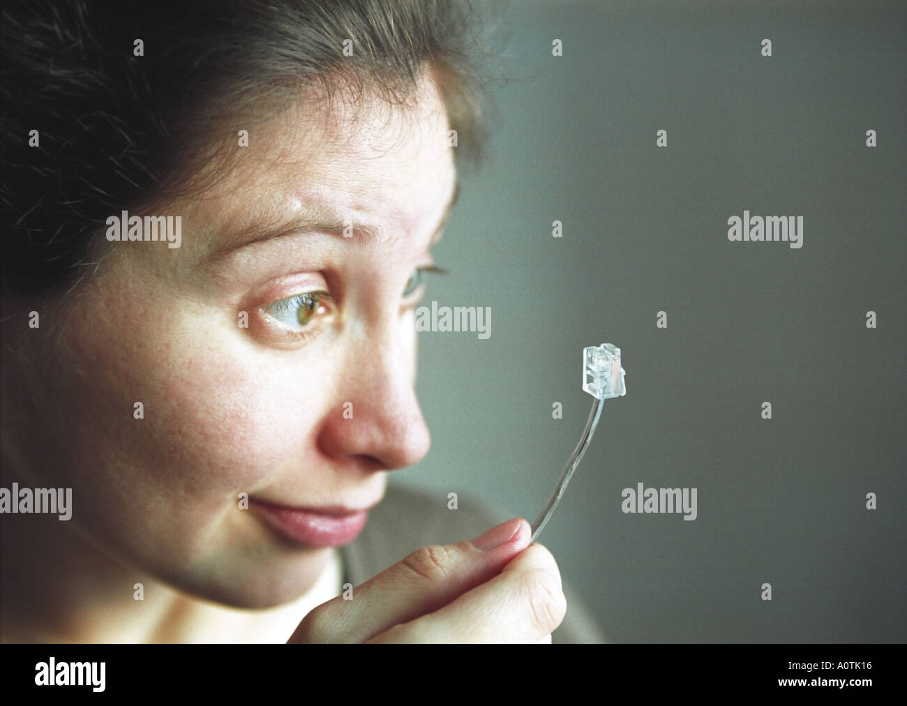 A woman is looking over a telephone plug  Stock Photo