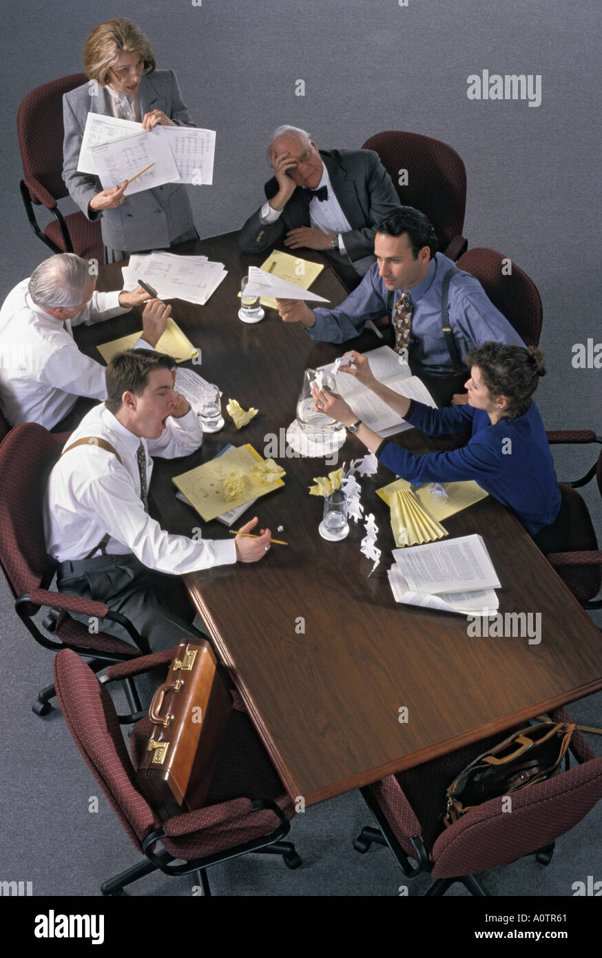 Humorous photo of bored, fatigued, unhappy, miserable and thoroughly worn-out co-workers around the conference table Stock Photo