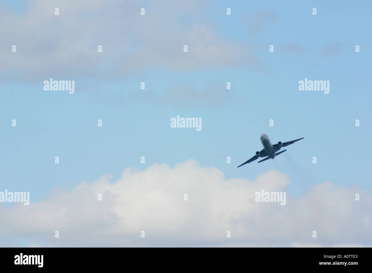 Plane flying in blue sky with clouds Stock Photo - Alamy