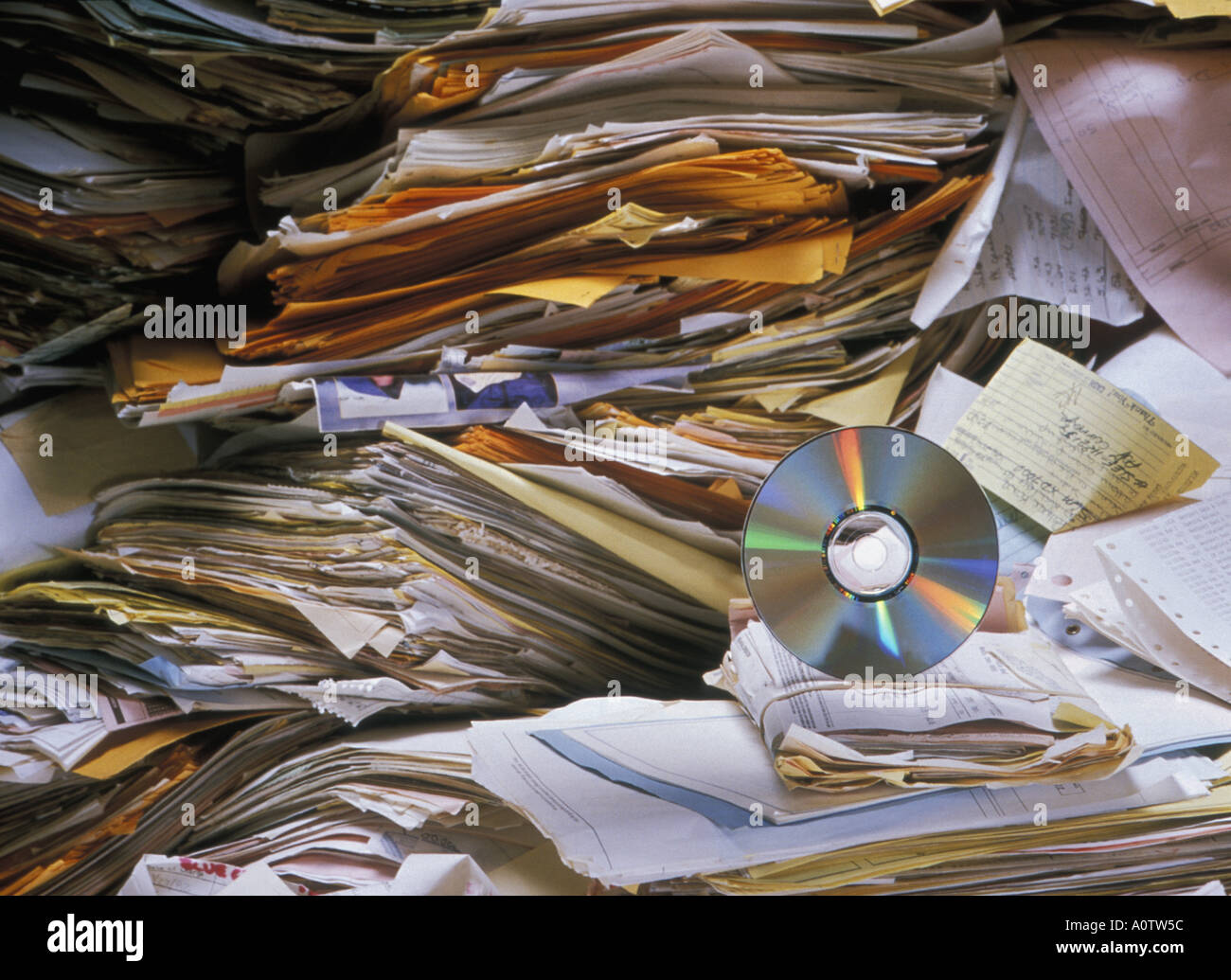 Still life of CD amongst piles of invoices bills and other financial papers, digitizing the entire mess on to a single CD Stock Photo