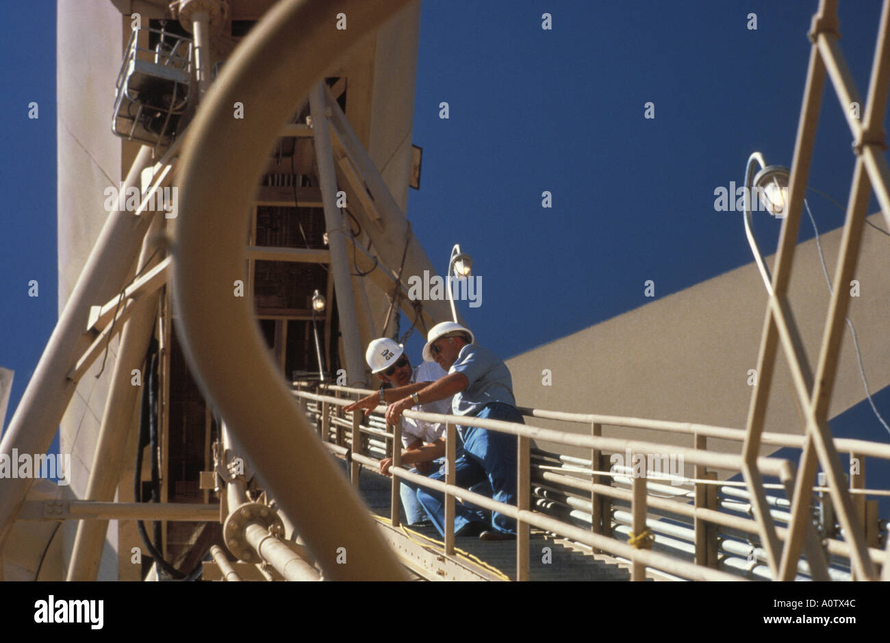 Engineers on elevated catwalk at wind turbine structure. Palm Springs, Ca, USA Stock Photo