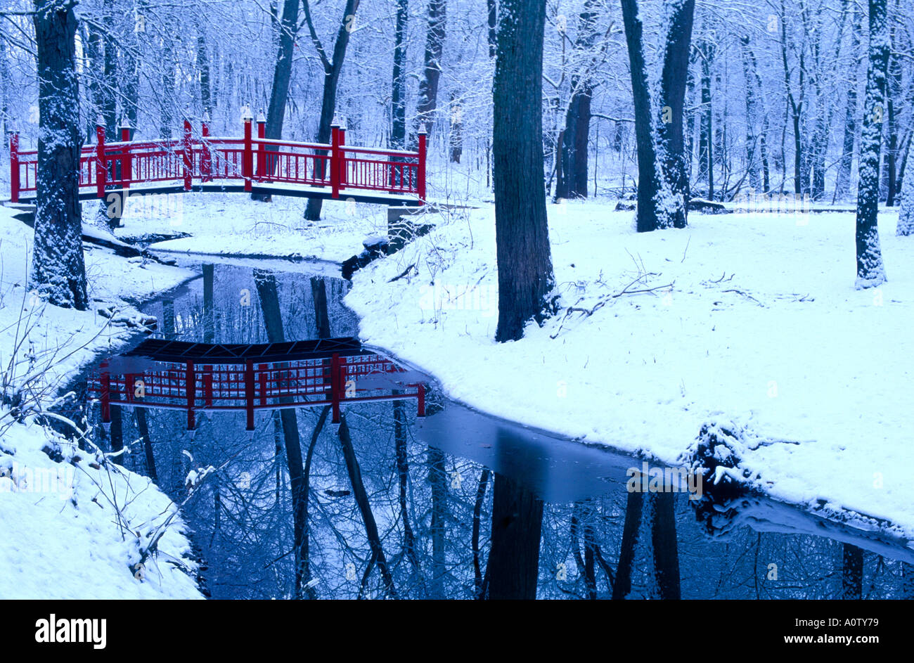 Red bridge over a creek in a snowy Lake of the Woods County Forest