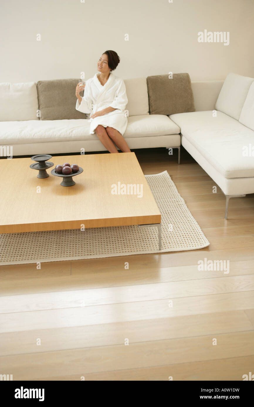Young woman sitting on a couch Stock Photo - Alamy