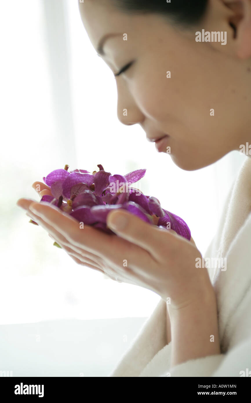 Close up of a young woman smelling a handful of flowers Stock Photo - Alamy