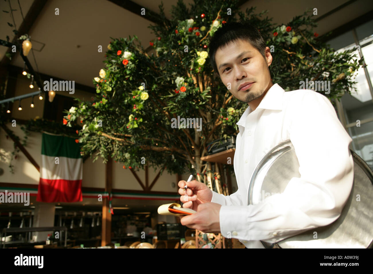 Side profile of a waiter taking an order in a restaurant Stock Photo