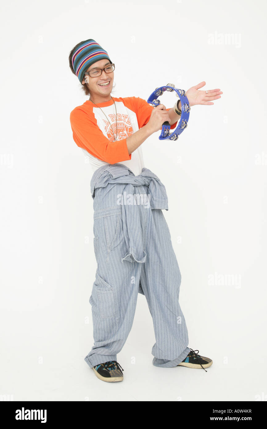 Young man playing the tambourine and smiling Stock Photo Alamy