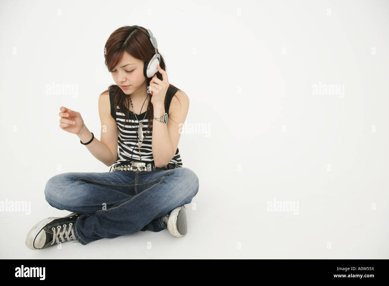 Young woman sitting on the floor and listening to music Stock Photo - Alamy