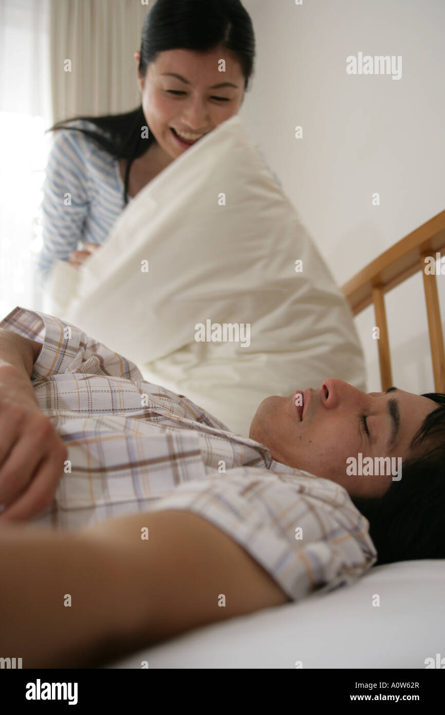 Side profile of a mid adult man sleeping on the bed with a mid adult ...