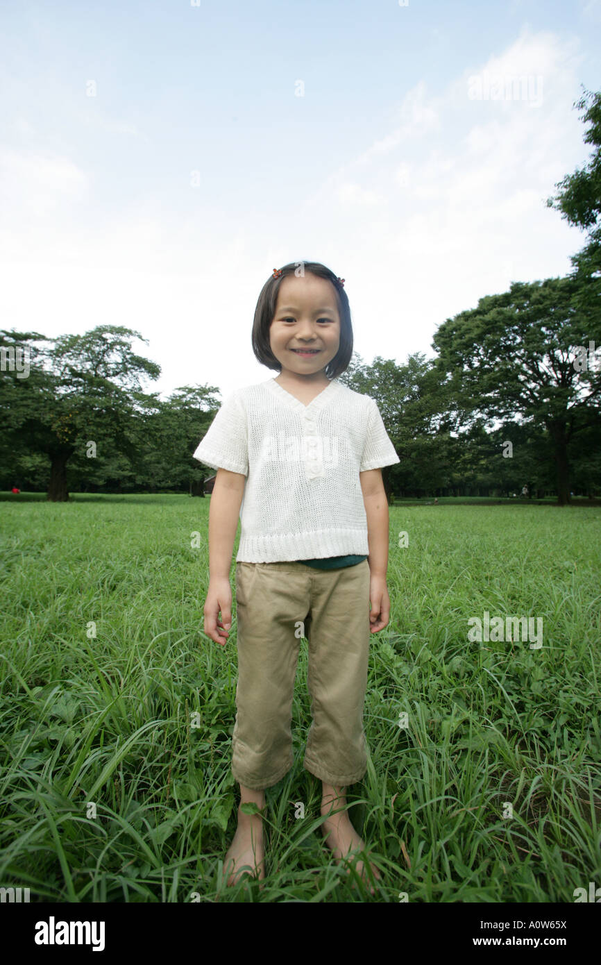 Portrait of a girl standing in a park Stock Photo - Alamy