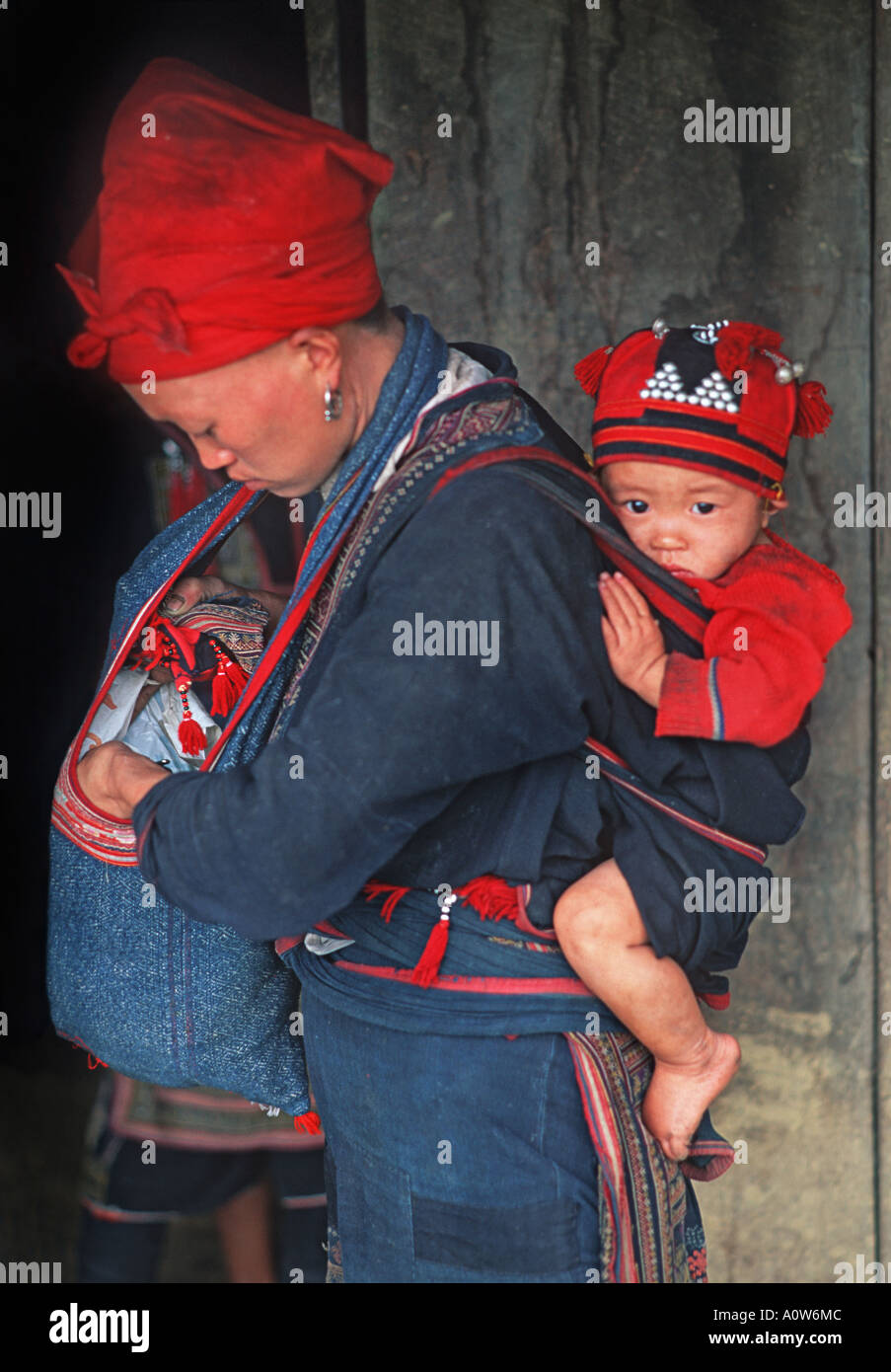 Mother with child worn in a carry cloth Red Dzao hilltribe minority Sapa region of Northern Vietnam Stock Photo