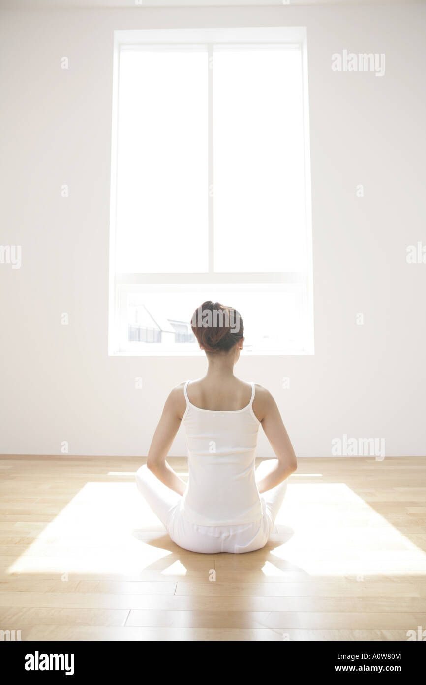Rear view of a young woman meditating Stock Photo - Alamy