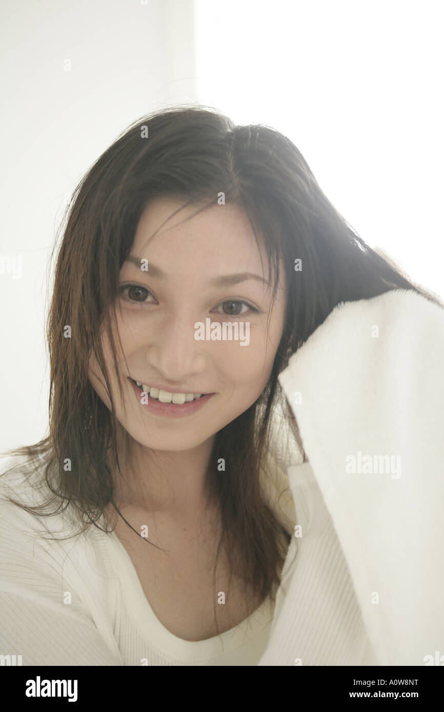 Portrait of a young woman drying her hair with a towel Stock Photo - Alamy