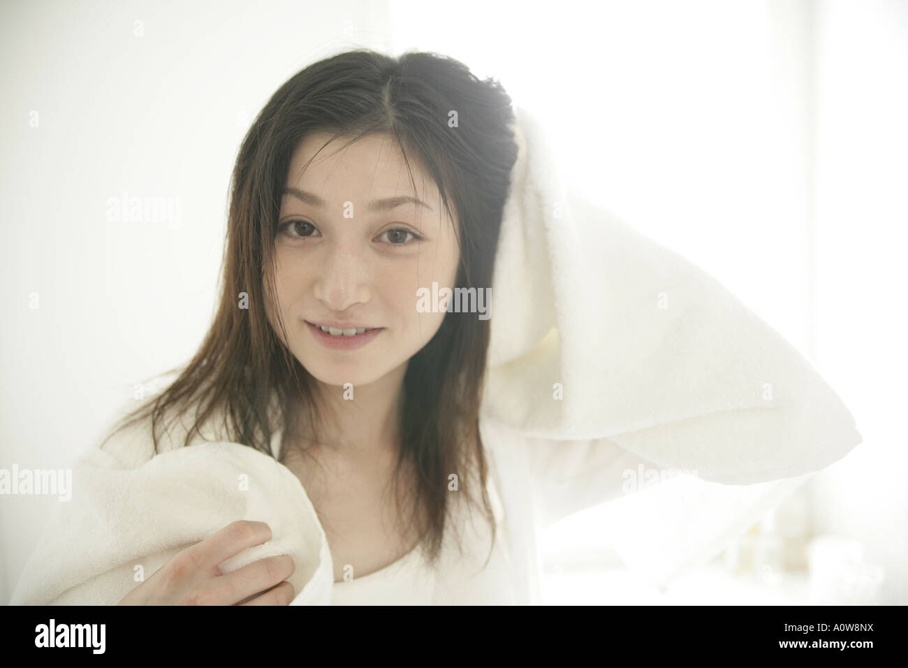 Portrait of a young woman drying her hair with a towel Stock Photo - Alamy