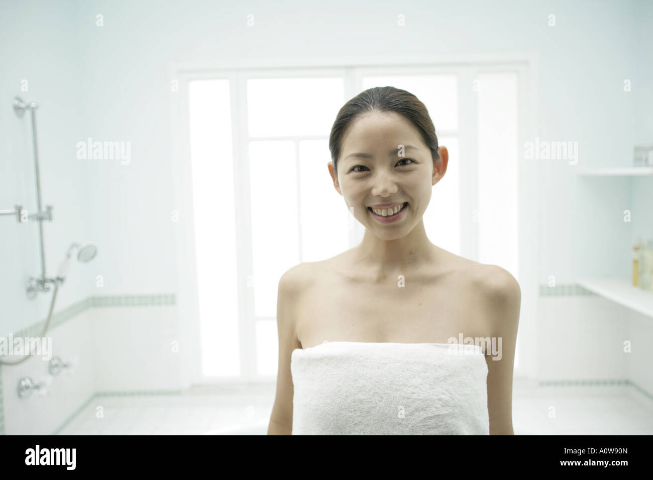 Portrait of a young woman wrapped in a towel and smiling Stock Photo ...