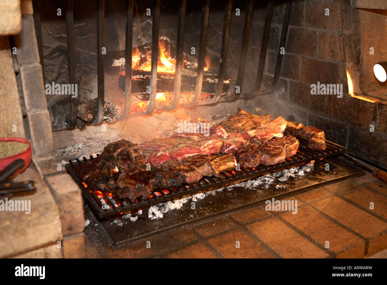 MEAT COOKING ON AN OPEN FIRE IN A FRENCH RESTAURANT IN THE SOUTH OF FRANCE Stock Photo