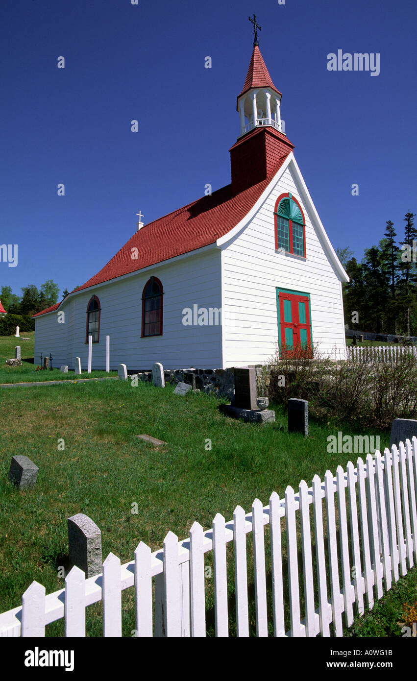 A quaint white church white picket fence and grave yard Quebec Canada