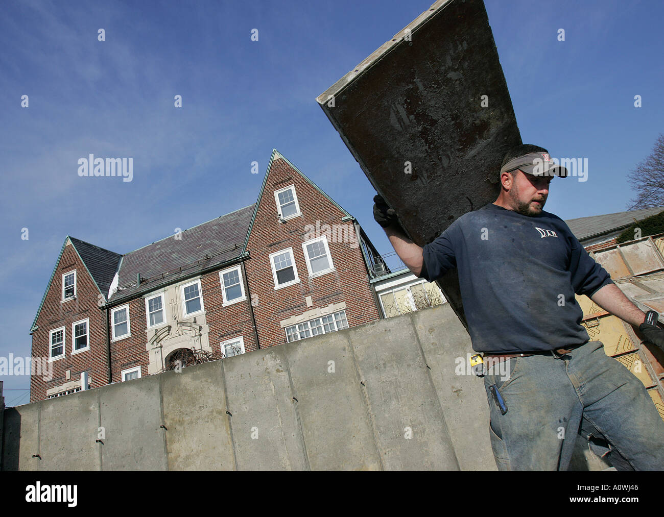 A worker carries a form for a cement foundation on a housing construction site Stock Photo